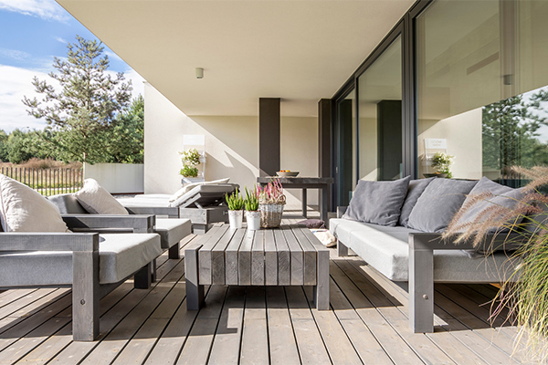 a modern, covered outdoor patio or terrace that is fully furnished for relaxation and entertaining